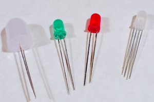 Four LED components. The one on the right is an RGB LED and has 4 wires coming out of it. The others each have two wires.