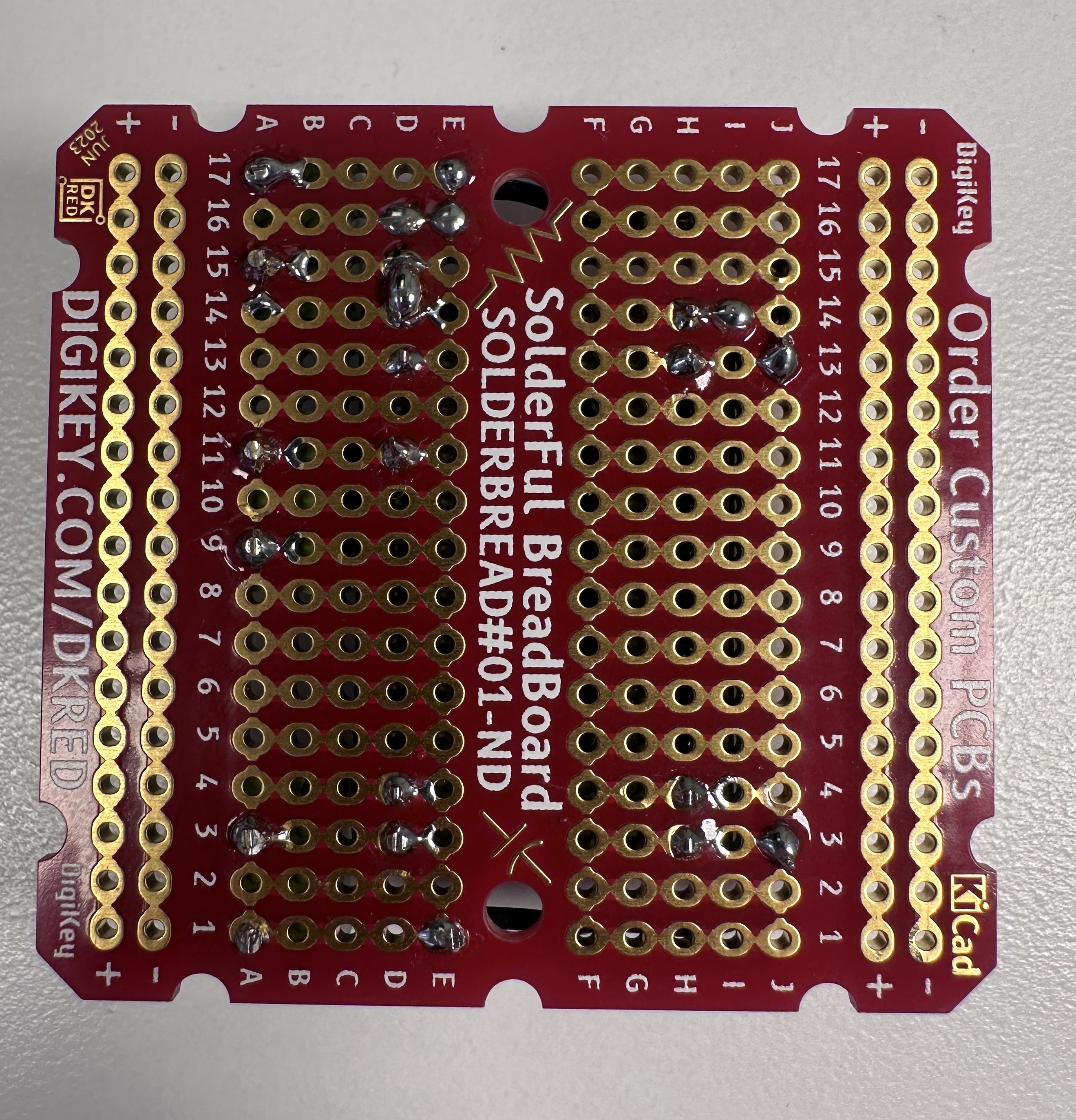 Photo of a  Meanwell NLDD1400H LED driver soldered to a printed circuit board, with screw terminals for connections, front view