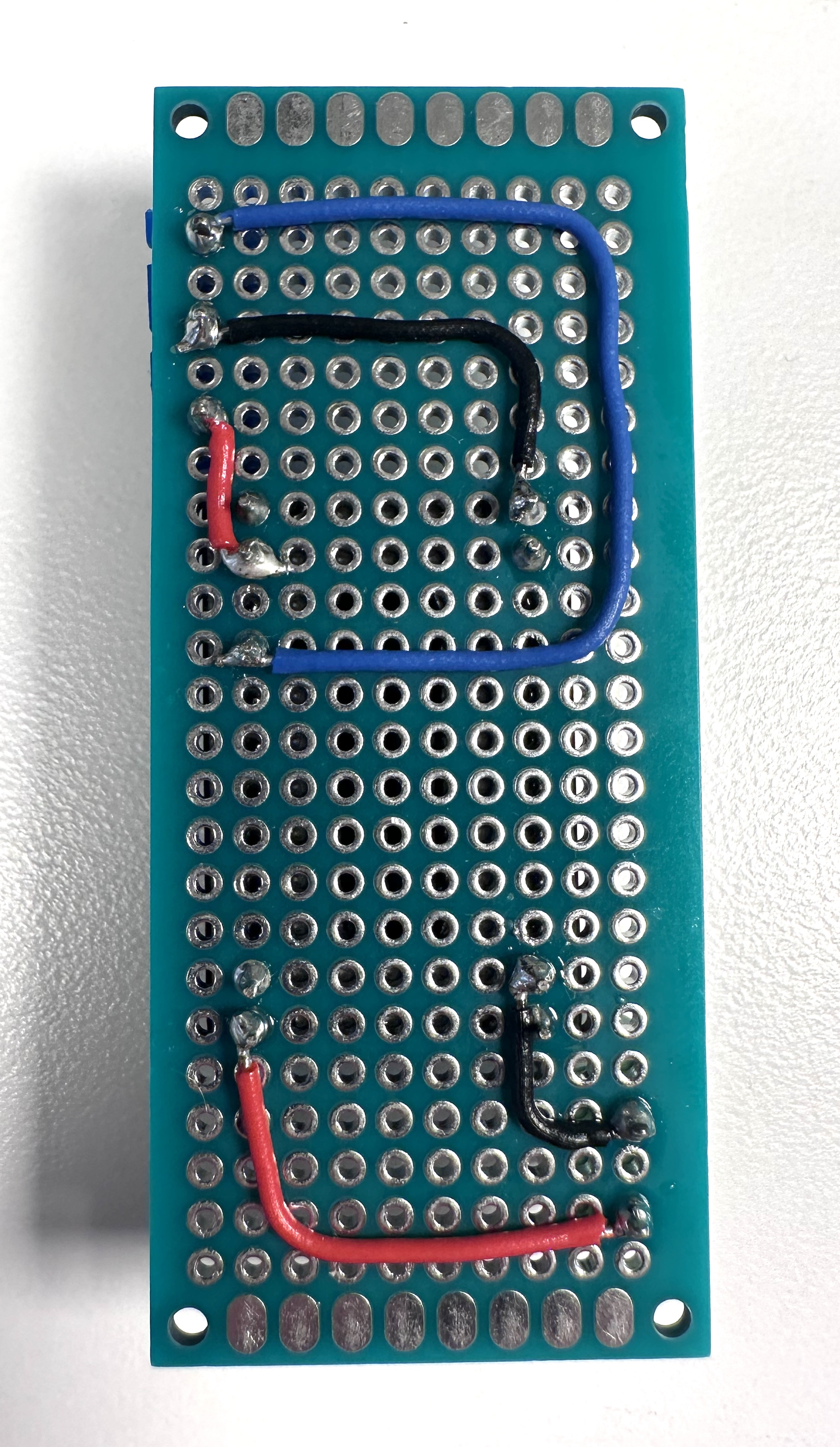 Photo of a  Meanwell NLDD1400H LED driver soldered to a printed circuit board, with screw terminals for connections, front view