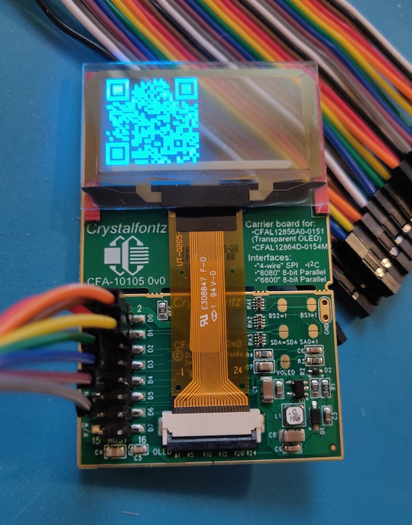 Photo of a SSD1309 transparent OLED showing a QR code.